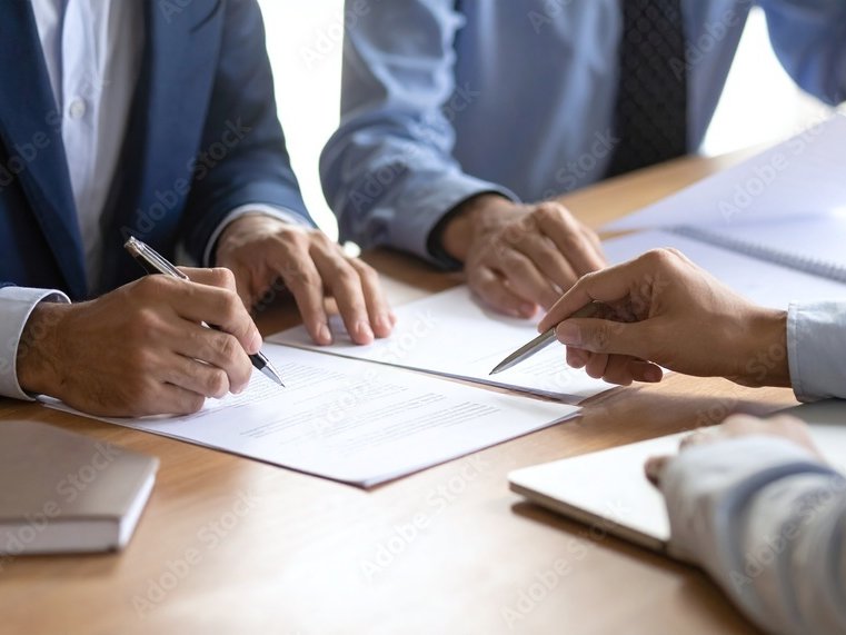 Gespräch am Besprechungstisch mit Unterlagen und Stift