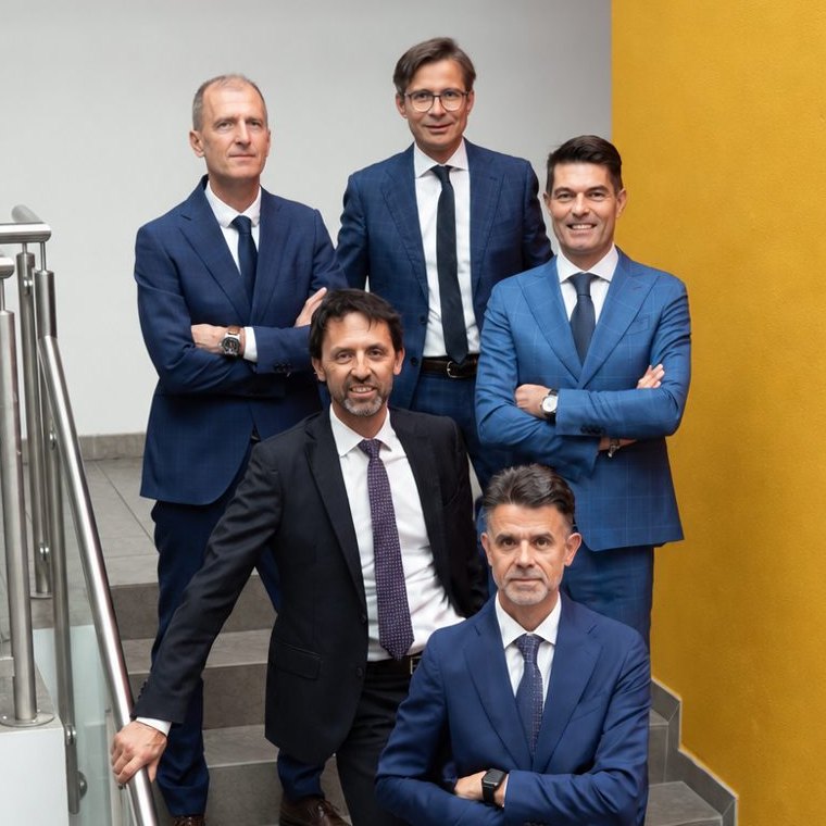 The firm's five partners on the stairs in the office